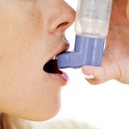 Woman Using an Inhaler --- Image by © Royalty-Free/Corbis