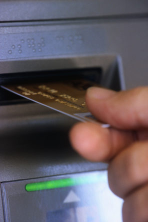 Person Putting a Card into an ATM